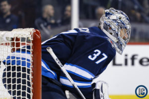 Connor Hellebuyck crouched in the net