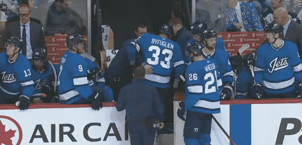 Dustin Byfuglien being helped off the ice at Jets bench